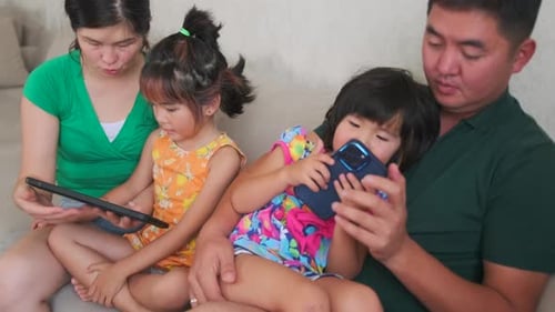 Family Relaxing at Home with Tablet and Smartphone