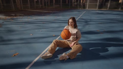 A Young and Energetic Athlete Engaging in Basketball on a Court in a Vibrant Urban Area