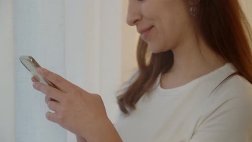 Cropped View of a Brunette Woman Typing Something on Her Smartphone Smiling Woman is Chatting with