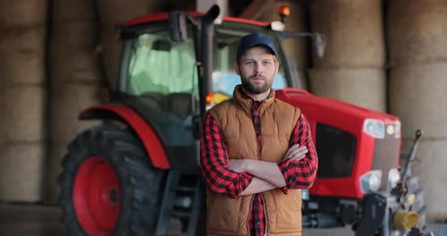 Bearded Farmer Poses in Front of Tractor