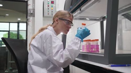 Scientist examines samples in laboratory safety enclosure