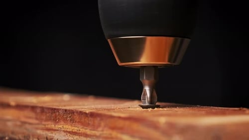 CloseUp of Unscrewing the Screw From a Block of Wood With a Screwdriver