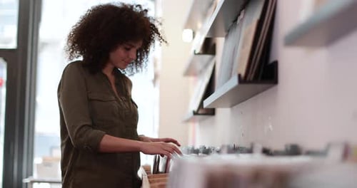 Young Adult female looking for records in a store