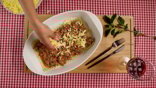Preparing Delicious Lasagna with Shredded Cheese and Red Wine