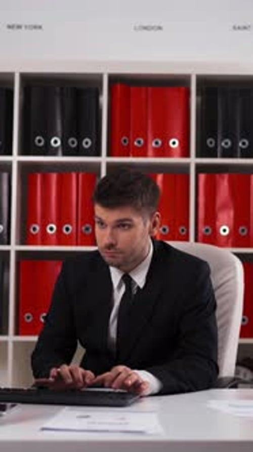 Vertical de un hombre de negocios que trabaja con una computadora de mesa en la oficina