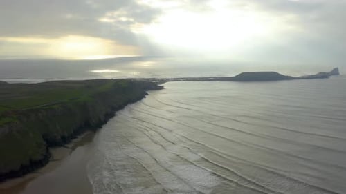Top-down aerial shot of the blue ocean waves crashing on the shore.