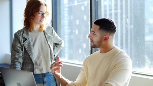 Creative Business People Talking At Laptop In Sunny Office Window