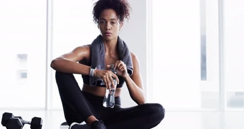 Woman drinking water, fitness and relax after sports and tired with hydration, health and wellness