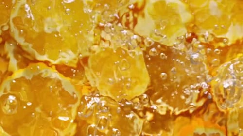 Super Slow Motion of Orange Slices with Ice Rotating in Water Black Background Filmed on High Speed