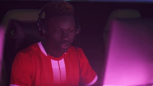 Excited Gamer Playing in Dark Neon Room