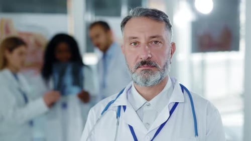 Portrait of Attractive Middle Aged Senior Caucasian Doctor in Medical Office Wearing Stethoscope on