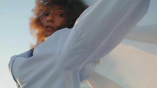 Fashionable Woman Holding Flowing Fabric at Sunset