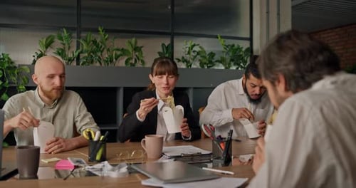 Office Colleagues Enjoy a Business Lunch Together Chatting Informally at the Table While Taking a