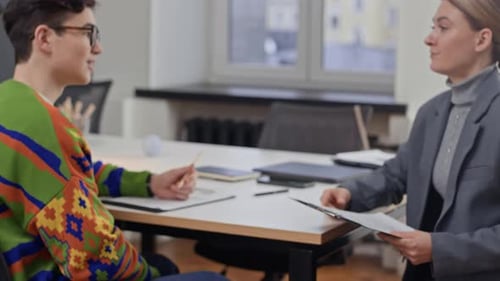 Joven empleado estrechando la mano del gerente de recursos humanos en una entrevista de trabajo
