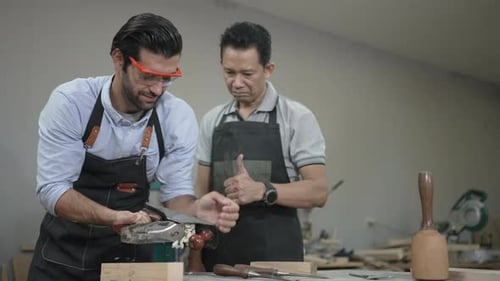 Carpenters are working together at workshop.