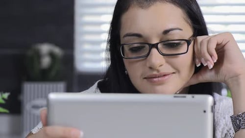 Smiling Woman Uses Tablet Device in Home
