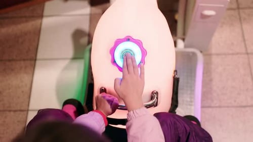 POV Little Girl's Hand is Pressing a Large Arcade Carousel Game's Button