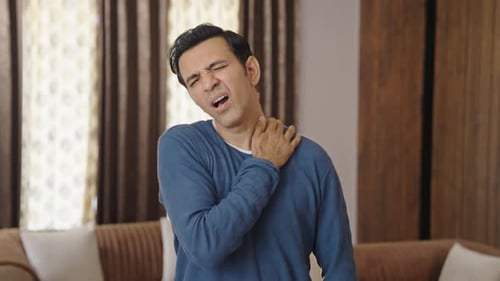 Man Massaging Stiff Neck in Home