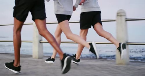 Friends, running and legs by beach for fitness, workout and outdoor training with marathon