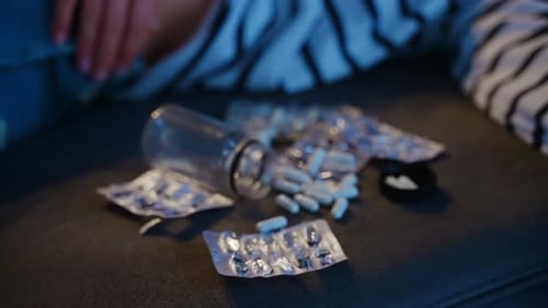 Woman Committed a Suicide By Drug Overdose Lies on Couch at Home Near Empty Blister Packs and Jar of