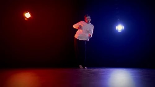 Enthusiastic Dancer Performing Under Red and Blue Lights
