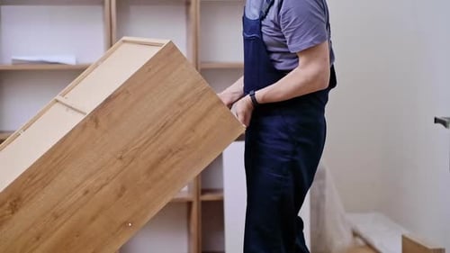Furniture Assembly and Installation Services Man in Professional Uniform Lifting Cabinet