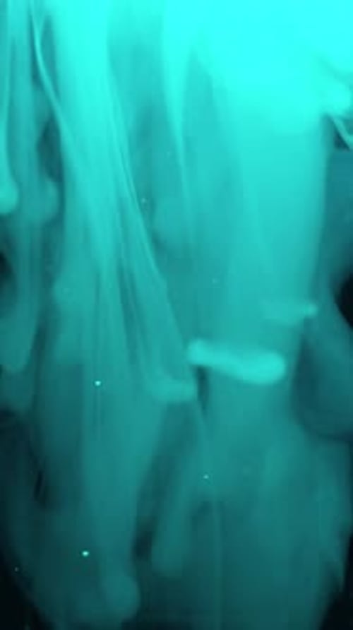Vertical Mystical and Ethereal Blue Smoke with Swirling Particles in Dark Environment