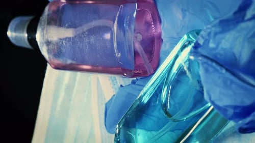 Protective medical face masks, gloves and hand sanitizers lying on table, close up