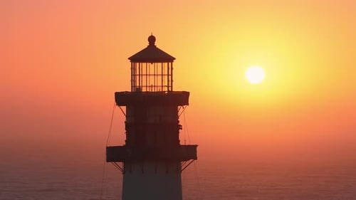 Pigeon Point Lighthouse at Sunset with Ocean Horizon and Setting Sun