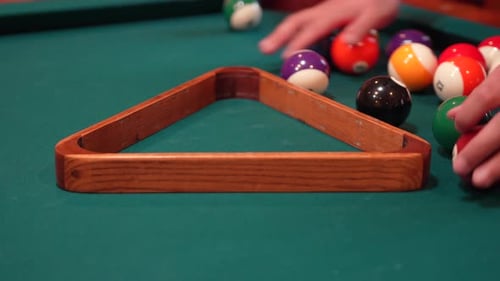 Person Racks 8 Ball Pool Triangle Closeup on the Spot then Rearranges Solid and Stripped Billiard Ba