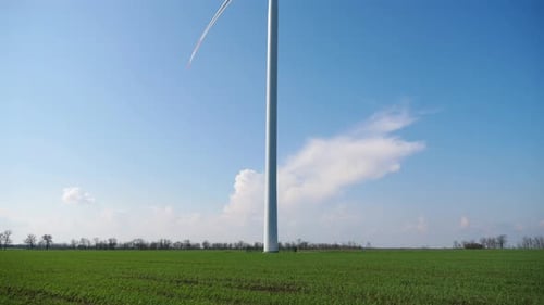 Majestic Wind Turbine Stands Tall Against a Bright Blue Sky Capturing Sunlight As Blades Rotate