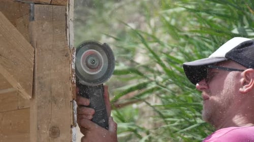 Man Cutting Wood with Grinding Wheel Tool