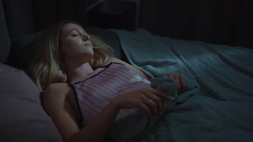 Woman Sleeping Peacefully in Her Bedroom at Night