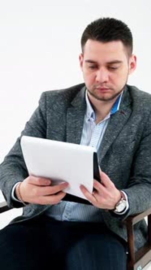Young Adult Male Reading Paperwork on Chair