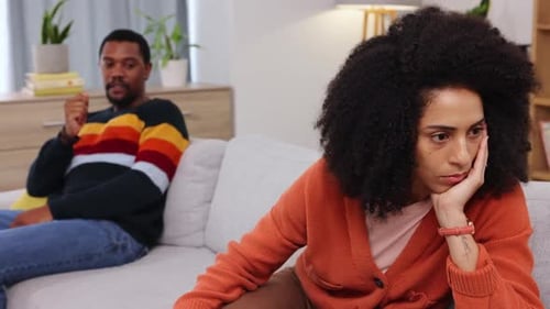 Upset Woman Sitting on Couch Next to Man