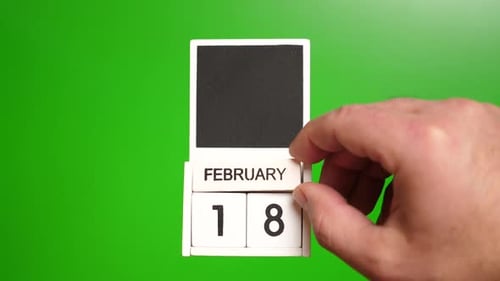 Hand Changing Calendar Date to February Eighteenth