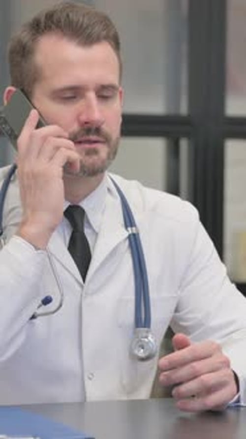 Concerned Doctor Talking on Phone in Office