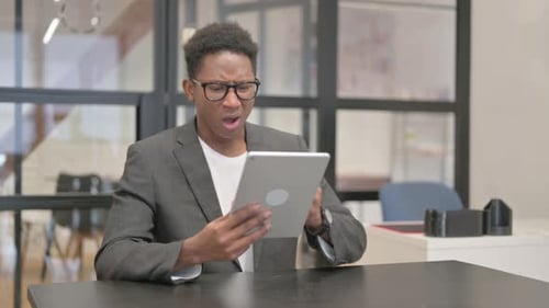 Young Adult Using Tablet Looking Frustrated in Office