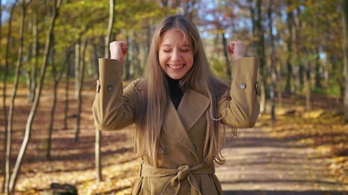 Happy Cheerful Lady Standing in Park Showing Hurray