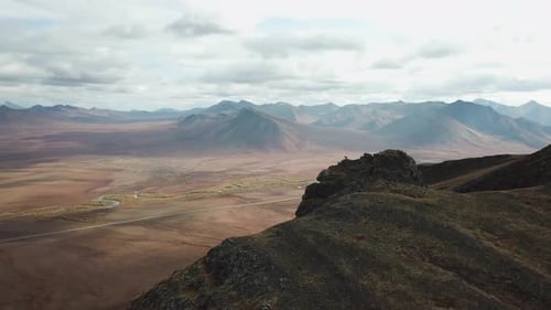 Hiker walking alone with stunning views of the Dempster highway in the Yukon
