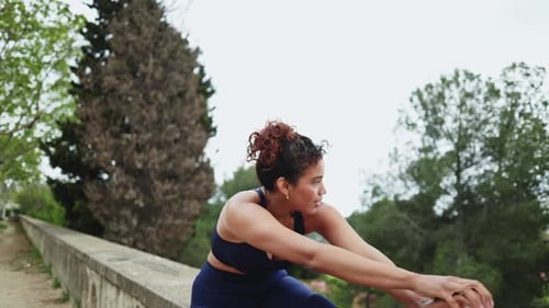 Young woman stretching legs in slow motion in a park