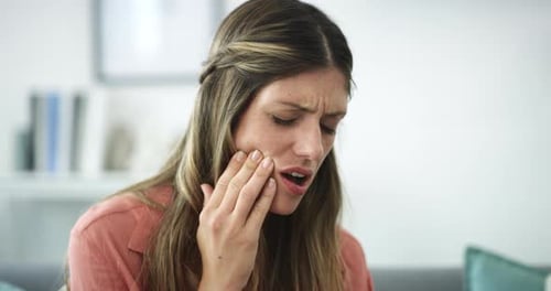 4k video footage of a woman experiencing a toothache while relaxing at home