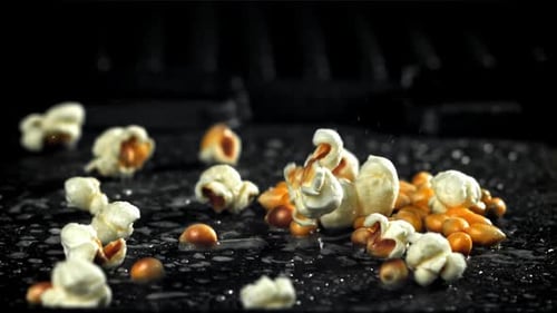 Du pop-corn explose dans une poêle avec une éclaboussure d'huile filmée par une caméra à haute vitesse à 1000 images par seconde