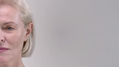 Halfportrait of 50s Middle Aged Old Woman in a Studio Senior Female is Smiling Looking at Camera
