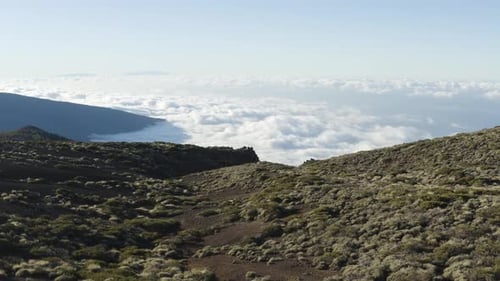 Volcanic landscape with cloud formation rolling in over Teide National Park, Tenerife. Drone forward