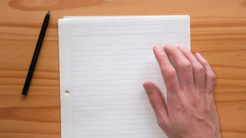 Of A Person Tapping His Fingers At The Blank Paper With A Black Pen On The Side. close up