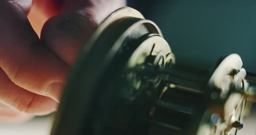 Slow motion close up of a professional watchmaker repairer working on a luxury mechanism watch gea
