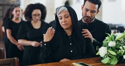 Funeral, coffin and sad woman at church, mourning or console for grief with support at ceremony