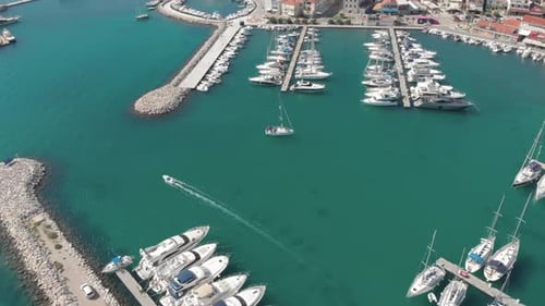 Aerial over anchored motorboats, yachts and sailboats in organized manner on the marina of coastal c