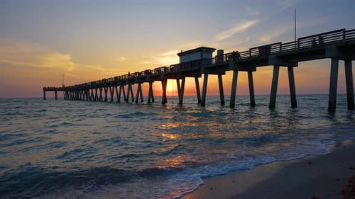Sunset Landscape at Venice Fishing Pier in Florida Ocean Surf Waves Crashing on Sandy Beach Covered